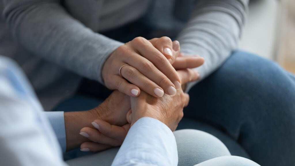 woman's hands holding another set of hands, consolingly