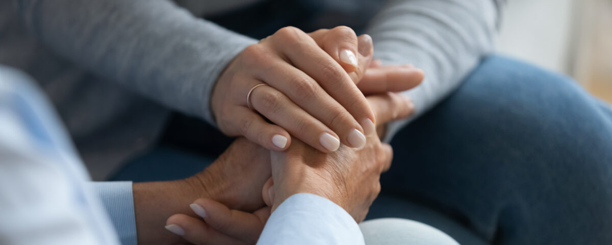 woman's hands holding another set of hands, consolingly