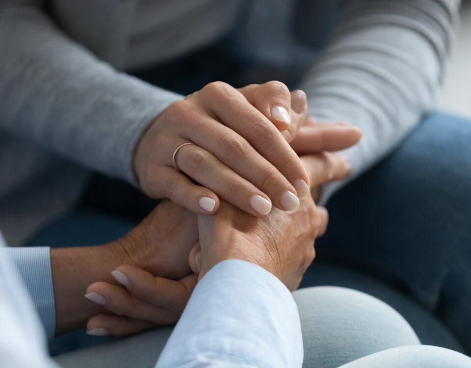 woman's hands holding another set of hands, consolingly