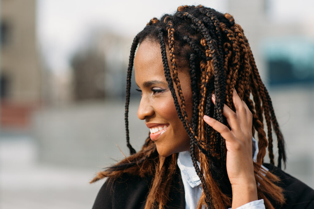 Smiling young Black woman with braids.
