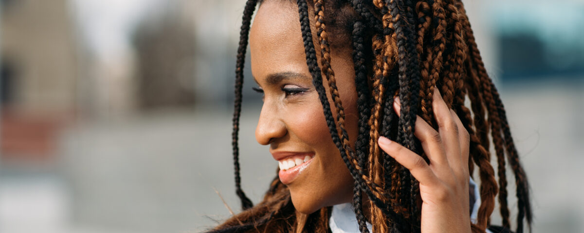 Smiling young Black woman with braids.