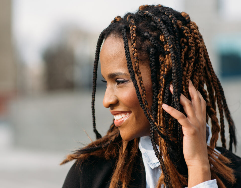 Smiling young Black woman with braids.