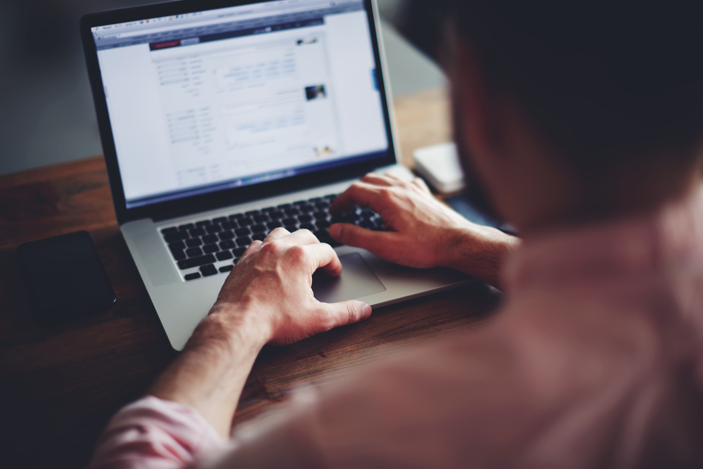 man typing on computer keyboard